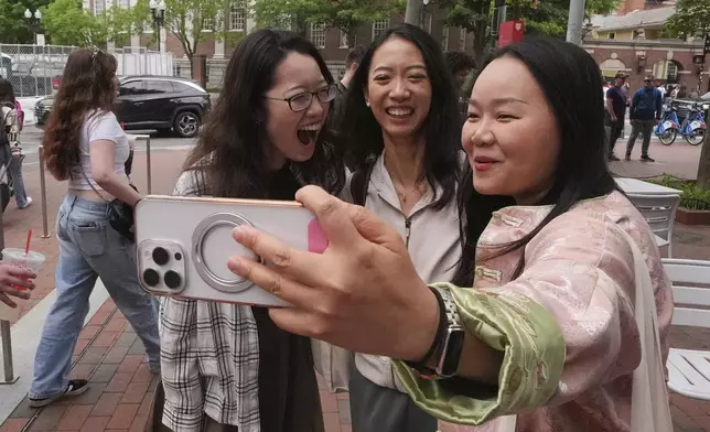 Yurong "Luanna" Jiang, center, who delivered a speech at her Harvard University commencement, takes a selfie with her college friends Cynthia Luo, right, and Helen Ji, Friday, May 30, 2025, in Cambridge, Mass. (AP Photo/Charles Krupa)