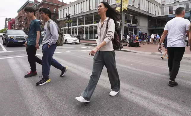 Yurong "Luanna" Jiang, who delivered a speech at her Harvard University commencement, crosses Massachusetts Avenue near the gates of Harvard Yard, Friday, May 30, 2025, in Cambridge, Mass. (AP Photo/Charles Krupa)