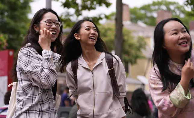 Yurong "Luanna" Jiang, center, who delivered a speech at her Harvard University commencement, jokes with her college friends Helen Ji, left, and Cynthia Luo, Friday, May 30, 2025, in Cambridge, Mass. (AP Photo/Charles Krupa)