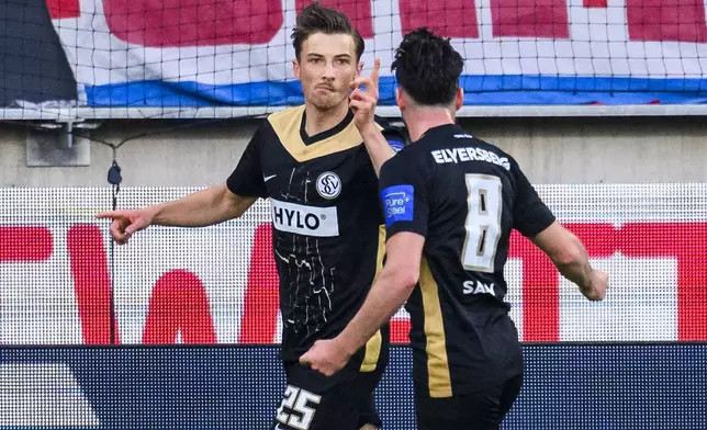 Elversberg's Lukas Petkov, left, celebrates with Semih Sahin (r) after scoring during a Bundesliga relegation playoff first leg soccer match between FC Heidenheim and SV Elversberg, Thursday, May 22, 2025, in Heidenheim, Germany. (Tom Weller/dpa via AP)