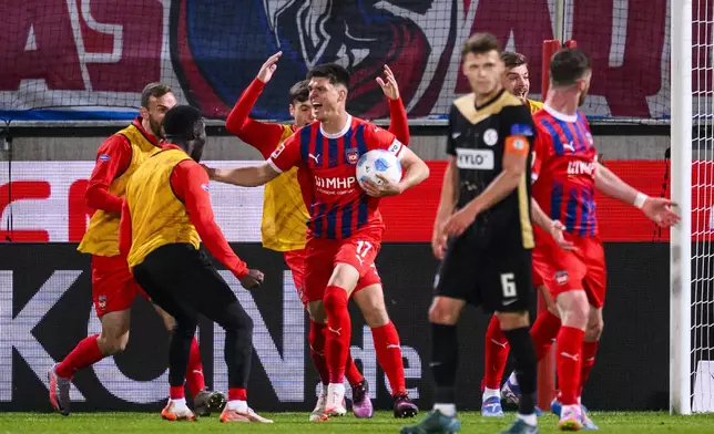 Heidenheim's Mathias Honsak, center, celebrates after his goal during a Bundesliga relegation playoff first leg soccer match between FC Heidenheim and SV Elversberg, Thursday, May 22, 2025, in Heidenheim, Germany. (Tom Weller/dpa via AP)