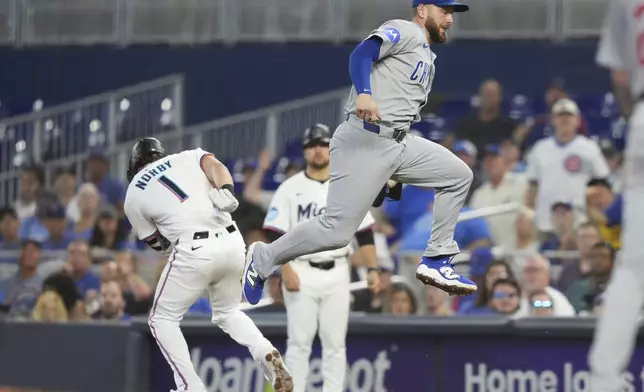 Miami Marlins' Connor Norby (1) beats the throw to Chicago Cubs first baseman Michael Busch, right, for a RBI-single to score Agustin Ramirez during the second inning of a baseball game Wednesday, May 21, 2025, in Miami. (AP Photo/Lynne Sladky)