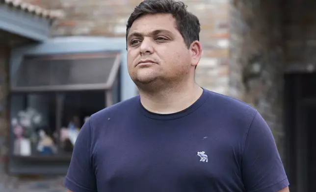 Spencer Goidel, an Equal Employment Opportunity Specialist with the Internal Revenue Service who was notified his job would be eliminated as part of the government's efficiency cuts, stands for a portrait outside his home in Boca Raton, Fla., April 16, 2025. (AP Photo/Daniel Kozin)