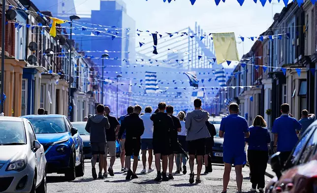 Everton fans make their way to the stadium before the English Premier League soccer match between Everton and Southampton, the last to be played at Goodison Park, Liverpool, England, Sunday, May 18, 2025. (Martin Rickett/PA via AP)