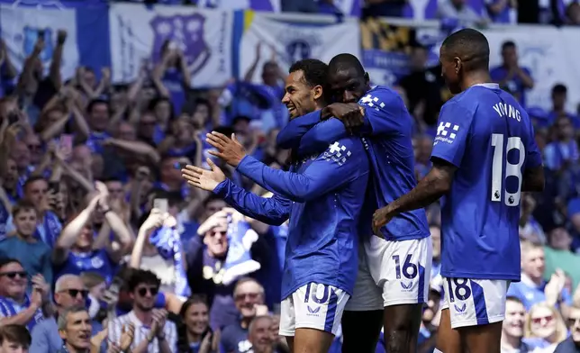 Everton's Iliman Ndiaye, left, celebrates scoring with Abdoulaye Doucoure and Ashley Young, right, during the English Premier League soccer match between Everton and Southampton at Goodison Park, Liverpool, England, Sunday May 18, 2025. (Martin Rickett/PA via AP)