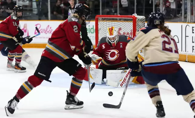 Ottawa Charge goaltender Gwyneth Philips (33) watches the puck as Aneta Tejralova (2) prepares to knock the puck away from Montreal Victoire's Maureen Murphy (21) during second period PWHL playoff hockey action in Ottawa, on Tuesday, May 13, 2025. (Justin Tang/The Canadian Press via AP)