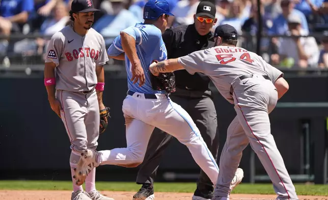 Kansas City Royals' Luke Maile (15) is tagged out by Boston Red Sox starting pitcher Lucas Giolito (54) after getting caught off base during the fifth inning of a baseball game Sunday, May 11, 2025, in Kansas City, Mo. (AP Photo/Charlie Riedel)