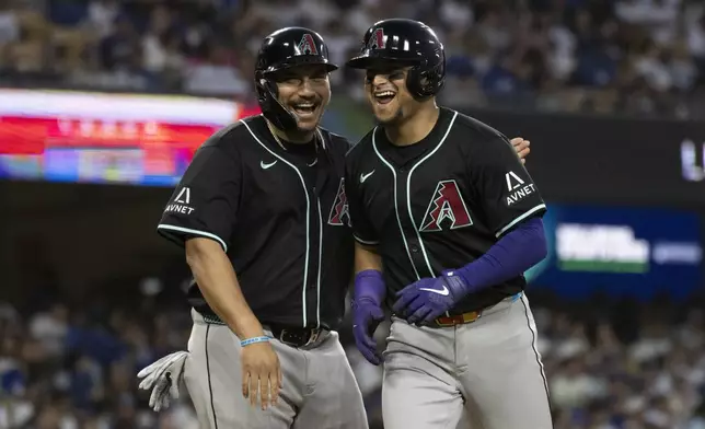 Arizona Diamondbacks' Gabriel Moreno, right, and Josh Naylor, left, celebrate after Moreno's two-run home run during the third inning of a baseball game against the Los Angeles Dodgers in Los Angeles, Monday, May 19, 2025. (AP Photo/Kyusung Gong)