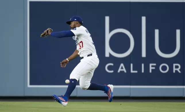 Los Angeles Dodgers right fielder Teoscar Hernández drops a fly ball during the first inning of a baseball game against the Arizona Diamondbacks in Los Angeles, Monday, May 19, 2025. (AP Photo/Kyusung Gong)