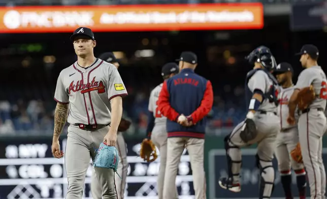 Atlanta Braves pitcher AJ Smith-Shawver, left, walks off the field after being removed from the game by manager Brian Snitker, center, during a baseball game in Washington, Thursday, May 22, 2025. (AP Photo/Terrance Williams)
