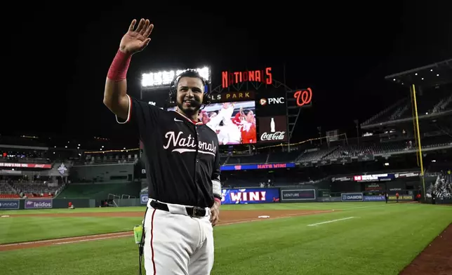 Washington Nationals' Keibert Ruiz waves to his parents while being interviewed after a baseball game against the Atlanta Braves in Washington, Thursday, May 22, 2025. (AP Photo/Terrance Williams)