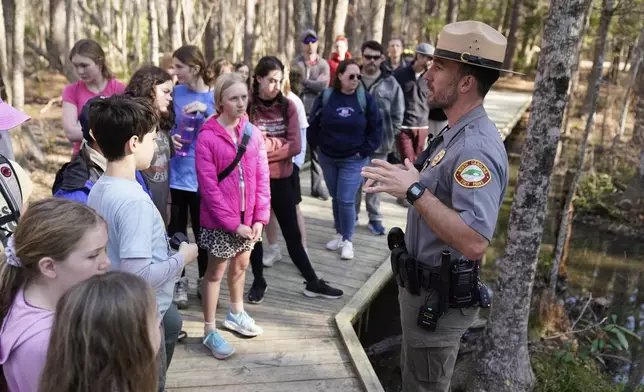 Park ranger Jesse Anderson speaks to visitors during a weekly carnivorous plant hike Saturday, March 22, 2025, in Carolina Beach, N.C. (AP Photo/Erik Verduzco)
