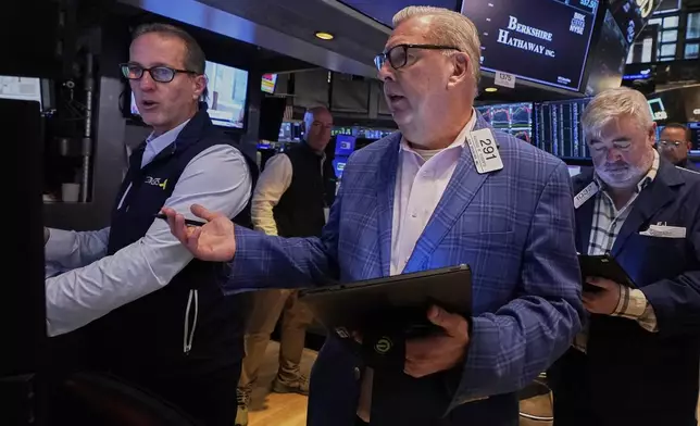 Specialist Glenn Carell, left, and trader Mathias Roberts, center, work on the floor of the New York Stock Exchange, Friday, May 2, 2025. (AP Photo/Richard Drew)