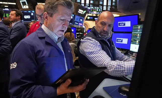 Trader James Matthews, left, and specialist James Denaro work on the floor of the New York Stock Exchange, Friday, May 2, 2025. (AP Photo/Richard Drew)