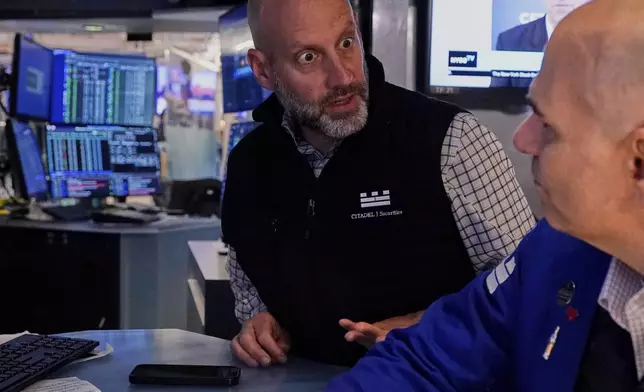 Specialists Meric Greenbaum, left, and Philip Finale confer on the floor of the New York Stock Exchange, Friday, May 2, 2025. (AP Photo/Richard Drew)