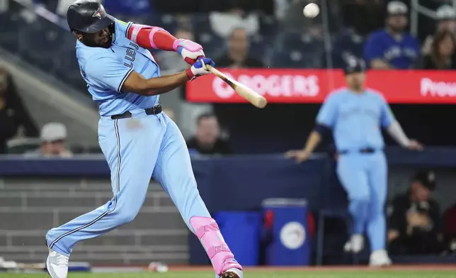 Toronto Blue Jays' Vladimir Guerrero Jr. (27) hits a two-run home run against the Athletics during the second inning of a baseball game in Toronto, Thursday, May 29, 2025. (Nathan Denette/The Canadian Press via AP)