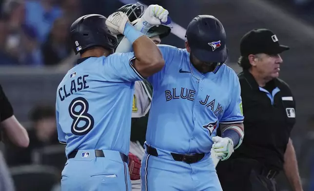 Toronto Blue Jays' Bo Bichette, right, celebrates his two-run home run against the Athletics with Jonatan Clase (8) during the third inning of a baseball game in Toronto, Thursday, May 29, 2025. (Nathan Denette/The Canadian Press via AP)