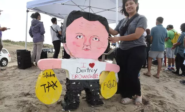 Natalia Salinas holds a piñata of Elon Musk during a protest at Boca Chica beach, Texas, on Saturday afternoon, May 3, 2025, hours before polls closed for the incorporation election that would turn Starbase into an official Texas city. (AP Photo/Valerie Gonzalez)