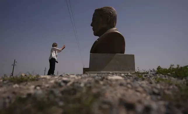 FILE - A visitor photographs a large bust of Elon Musk near SpaceX's Starbase as the Starship is prepared for a test flight in Boca Chica, Texas, March 5, 2025. (AP Photo/Eric Gay, File)