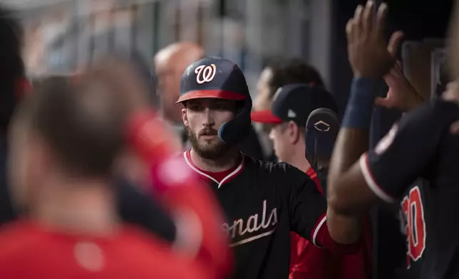 Washington Nationals' Dylan Crews (3) celebrates in the dugout after scoring in the seventh inning of a baseball game against the Atlanta Braves Wednesday, May 14, 2025 in Atlanta. (AP Photo/Kathryn Skeean)