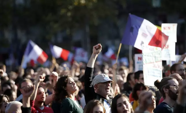 FILE - A supporter of French far-left leader Jean-Luc Melenchon raises his fist as his leader delivers his speech during a protest over the president's labor reform in Paris, France, Sept. 23, 2017. (AP Photo/Christophe Ena, File)