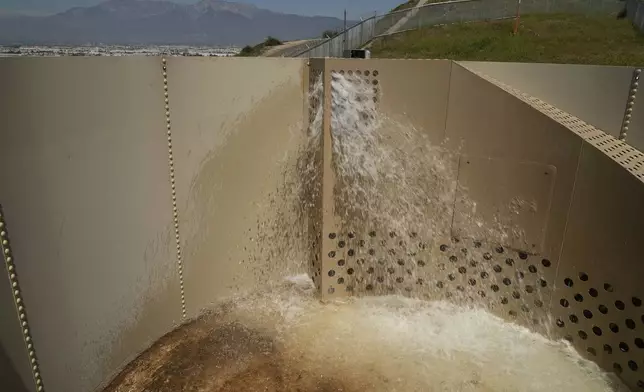 A Heli-Hydrant, a small, open tank that helicopters can rely on to get water faster for urban fires, fills with water during a demonstration Thursday, April 10, 2025, in Jurupa Valley, Calif. (AP Photo/Brittany Peterson)