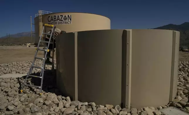 Glenn Chavez tests a newly installed Heli-Hydrant, a small, open tank that helicopters can rely on to get water faster for urban fires, Friday, April 11, 2025, in Cabazon, Calif. (AP Photo/Brittany Peterson)