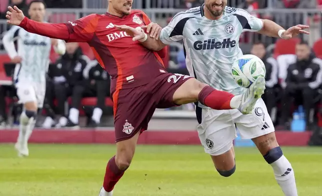 Toronto FC' Raoul Petretta, left, clears the ball away from New England Revolution' Leonardo Campana (9) during the second half of an MLS soccer match in Toronto, Saturday, May 3, 2025. (Frank Gunn/The Canadian Press via AP)