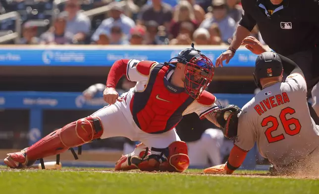 Minnesota Twins catcher Christian Vazquez, left, tags out Baltimore Orioles' Emmanuel Rivera at home in the sixth inning of a baseball game Thursday, May 8, 2025, in Minneapolis. (AP Photo/Bruce Kluckhohn)