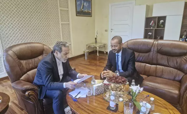 In this photo released by the Iranian Foreign Ministry, Iranian Foreign Minister Abbas Araghchi, left, reads a paper in a meeting with his Omani counterpart Sayyid Badr Albusaidi at the Omani Embassy in Rome during the fifth round of Iran-U.S. negotiations, Friday, May 23, 2025. (Iranian Foreign Ministry via AP)