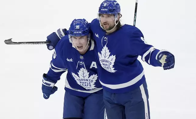 Toronto Maple Leafs' Mitch Marner (16) celebrates his goal with Chris Tanev (8) during the third period of an NHL hockey playoff game against the Florida Panthers in Toronto on Wednesday, May 7, 2025. (Nathan Denette/The Canadian Press via AP)