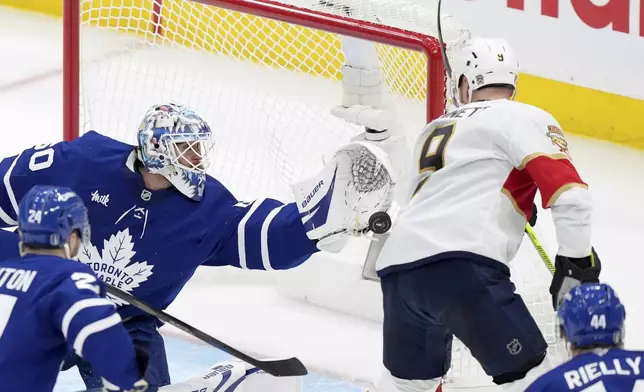 Toronto Maple Leafs goaltender Joseph Woll (60) makes a save against Florida Panthers' Sam Bennett (9) during the third period of an NHL hockey playoff game in Toronto on Wednesday, May 7, 2025. (Nathan Denette/The Canadian Press via AP)