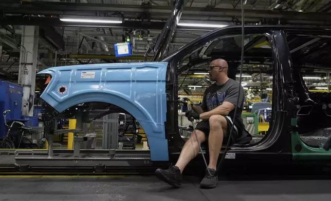 A vehicle assembly technician works on a 2025 Ford Expedition during a media tour to launch the 2025 Ford Expedition at the Ford Motor Company Kentucky Truck Plant, Wednesday, April 30, 2025, in Louisville, Ky. (AP Photo/Carolyn Kaster)