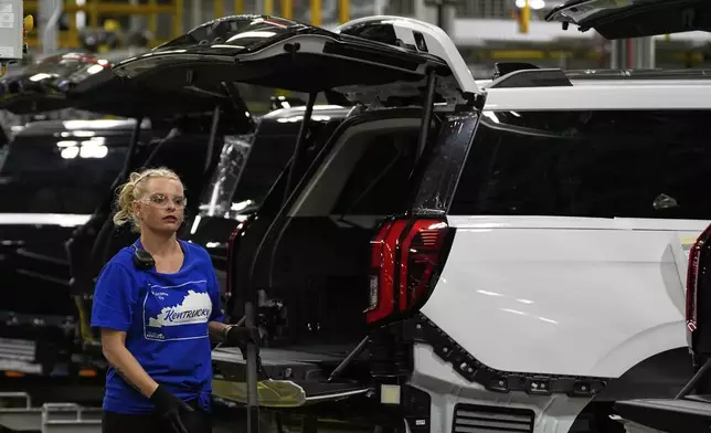 A vehicle assembly technician works on 2025 Ford Expeditions during a media tour to launch the 2025 Ford Expedition at the Ford Motor Company Kentucky Truck Plant, Wednesday, April 30, 2025, in Louisville, Ky. (AP Photo/Carolyn Kaster)