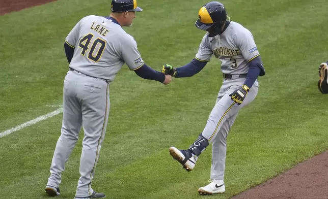 Milwaukee Brewers' Joey Ortiz, right, celebrates with third base coach Jason Lane (40) as he rounds third base after hitting a solo home run off Pittsburgh Pirates pitcher Mike Burrows during the second inning of a baseball game in Pittsburgh, Thursday, May 22, 2025. (AP Photo/Gene J. Puskar)