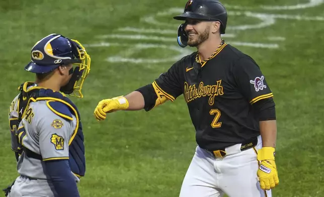 Pittsburgh Pirates' Spencer Horwitz (2) crosses home plate in front of Milwaukee Brewers catcher William Contreras after hitting a solo home run off Brewers pitcher Aaron Civale during the fourth inning of a baseball game in Pittsburgh, Thursday, May 22, 2025. (AP Photo/Gene J. Puskar)