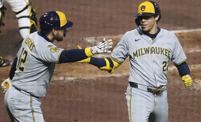 Milwaukee Brewers' Christian Yelich, right, is greeted by Rhys Hoskins as he returns to the dugout after hitting a solo home run off Pittsburgh Pirates pitcher Isaac Mattson during the sixth inning of a baseball game in Pittsburgh, Thursday, May 22, 2025. (AP Photo/Gene J. Puskar)