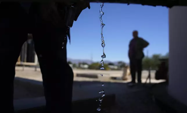 FILE - Water drips from a faucet as water operator Robert Tipton checks equipment for a well at the Wenden Domestic Water Improvement District's offices, Oct. 17, 2023, in Wenden, Ariz. (AP Photo/John Locher, File)