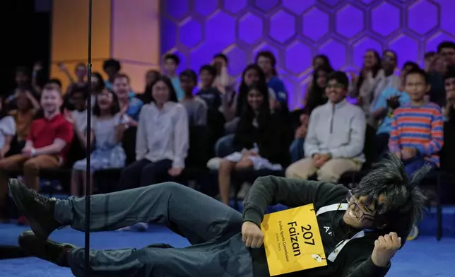 Faizan Zaki, 13, of Dallas, falls to the stage after winning the 2025 Scripps National Spelling Bee at the Gaylord National Resort &amp; Convention Center Thursday, May 29, 2025, in Oxon Hill, Md. (AP Photo/Jose Luis Magana)