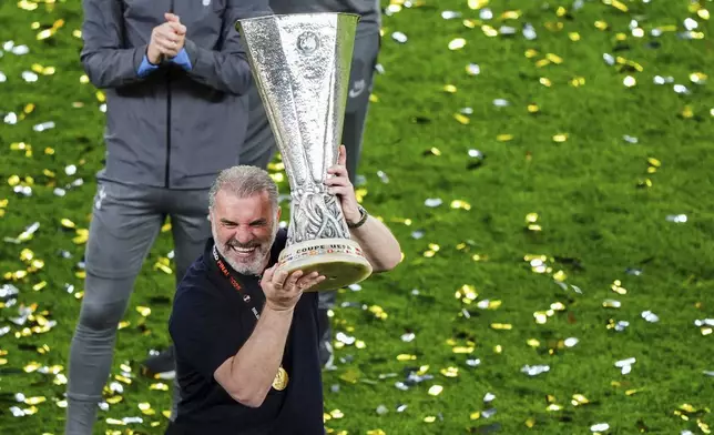 Tottenham Hotspur manager Ange Postecoglou lifts the Europa League trophy following the team's victory over Manchester United at the Estadio de San Mames, Bilbao, Spain, Wednesday, May 21, 2025. (Andrew Milligan/PA via AP)