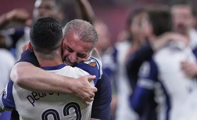 Tottenham's head coach Ange Postecoglou celebrates with Tottenham's Pedro Porro after the Europa League final soccer match between Tottenham Hotspur and Manchester United at the San Mames Stadium in Bilbao, Spain, Wednesday, May 21, 2025. (AP Photo/Jose Breton)