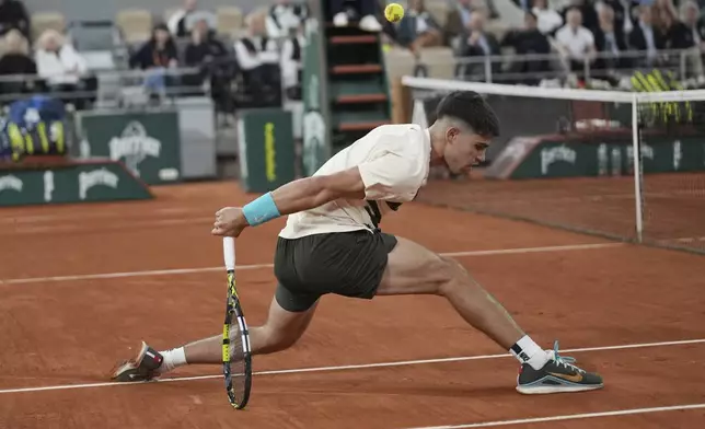 Spain's Carlos Alcaraz returns the ball to Hungary's Fabian Maroszan during their second round match of the French Tennis Open, at the Roland-Garros stadium, in Paris, Wednesday, May 28, 2025. (AP Photo/Christophe Ena)
