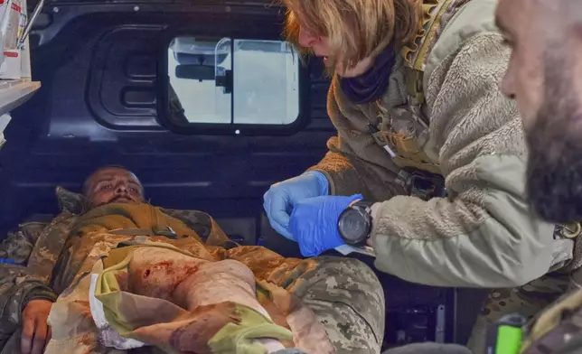 In this photo provided by Ukraine's 65th Mechanized Brigade press service, a paramedic gives first aid to a wounded soldier at the frontline in Zaporizhzhia region, Ukraine, Monday, May 5, 2025. (Andriy Andriyenko/Ukraine's 65th Mechanized Brigade via AP)