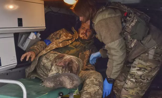 In this photo provided by Ukraine's 65th Mechanized Brigade press service, a paramedic gives first aid to a wounded soldier at the frontline in Zaporizhzhia region, Ukraine, Monday, May 5, 2025. (Andriy Andriyenko/Ukraine's 65th Mechanized Brigade via AP)