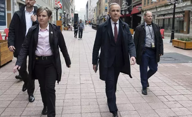 Prime Minister Mark Carney walks to his first news conference after winning the federal election, in Ottawa, Friday, May 2, 2025. (Adrian Wyld/The Canadian Press via AP)