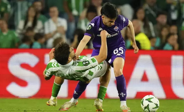 Fiorentina's Fabiano Parisi pusges Betis' Abde Ezzalzouli during the Conference League semifinal first leg soccer match between Betis and Fiorentina at the Benito Villamarin stadium in Seville, Spain, Thursday, May 1, 2025. (AP Photo/Jose Breton)