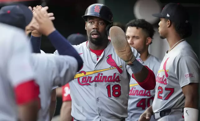 St. Louis Cardinals' Jordan Walker (18) celebrates with teammates after scoring on a single by Victor Scott II during the third inning of the second baseball game of a doubleheader against the Cincinnati Reds Wednesday, April 30, 2025, in Cincinnati. (AP Photo/Jeff Dean)