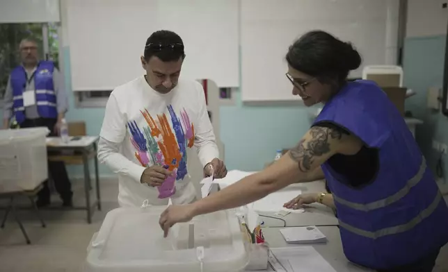 A Lebanese man casts his ballot at a polling station during municipal elections in the southern suburbs of Beirut, Lebanon, Sunday, May 4, 2025. (AP Photo/Hassan Ammar)