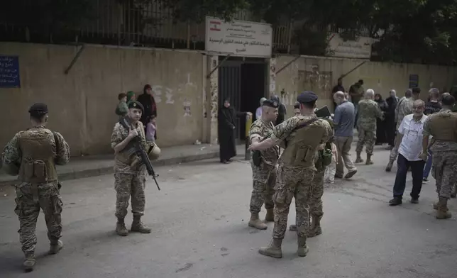 Lebanese army soldiers secure the area as voters arrive at a polling station during municipal elections in the southern suburbs of Beirut, Lebanon, Sunday, May 4, 2025. (AP Photo/Hassan Ammar)