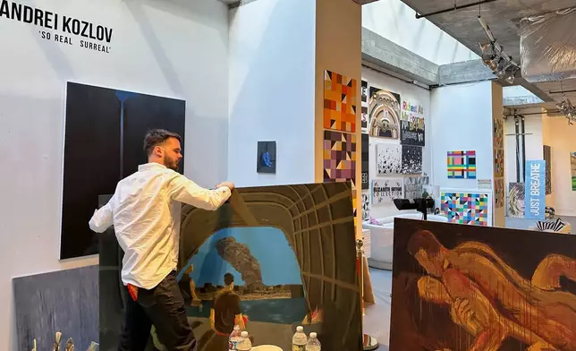 Andrei Kozlov, who was taken hostage by Hamas during the Oct. 7, 2023, attack on Israel, carries a painting through his studio Monday, May 19, 2025, in New York. (AP Photo/Matt Sedensky)